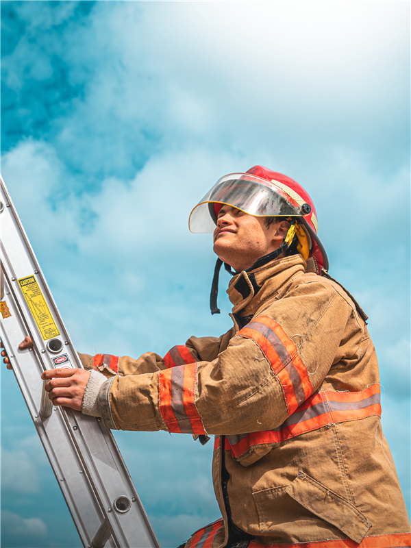 Public Safety Student on ladder with fire equipment on